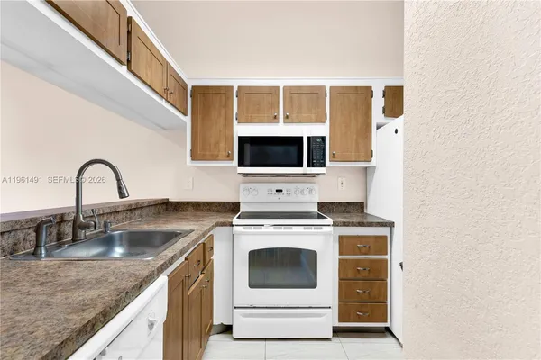 a kitchen with granite countertop a sink and cabinets