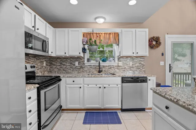 a kitchen with stainless steel appliances granite countertop a stove sink and cabinets