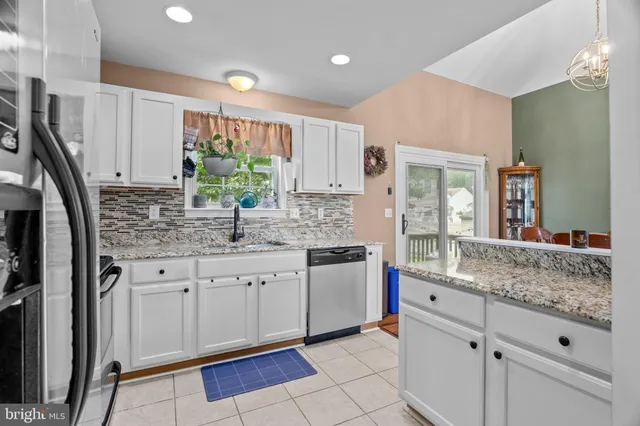 a kitchen with granite countertop white cabinets and white appliances