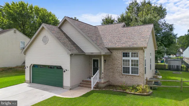 a view of a house with a yard potted plants and a table