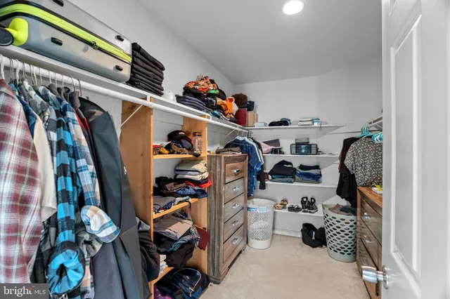 a view of walk in closet with clothes and shoes