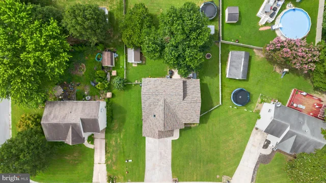 an aerial view of a house with outdoor space and trees all around