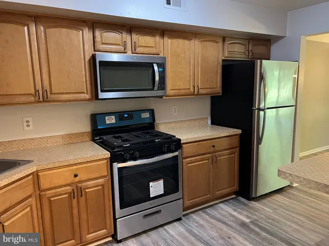 a kitchen with stainless steel appliances a stove a microwave and a refrigerator