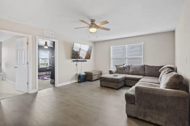 a living room with furniture and a wooden floor