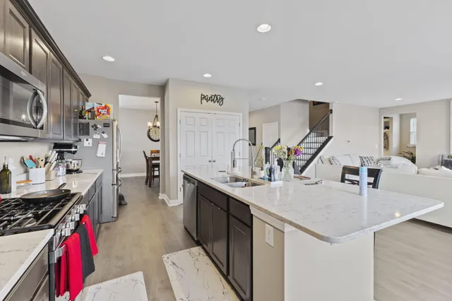 a kitchen with stainless steel appliances granite countertop a sink stove and refrigerator