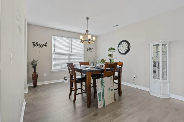 a dining room with furniture a chandelier and wooden floor