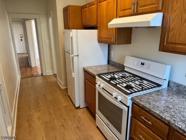 a kitchen with granite countertop a sink stove and cabinets