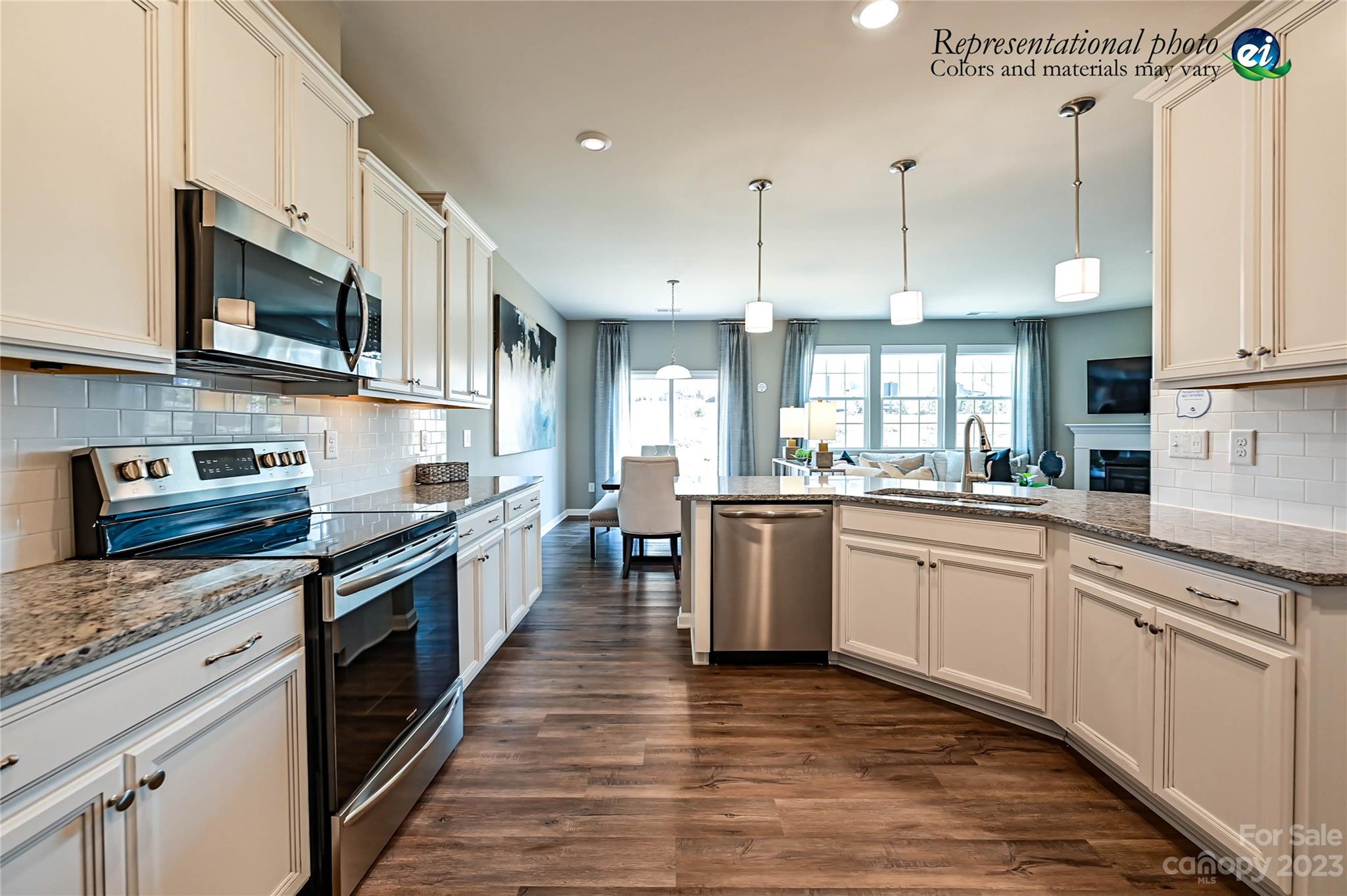 5653 Soft Shell Drive, Unit 376 Lancaster, SC 29720 - Photo 12 of 30 a large kitchen with stainless steel appliances granite countertop a stove top oven a sink dishwasher a dining table and chairs with wooden floor