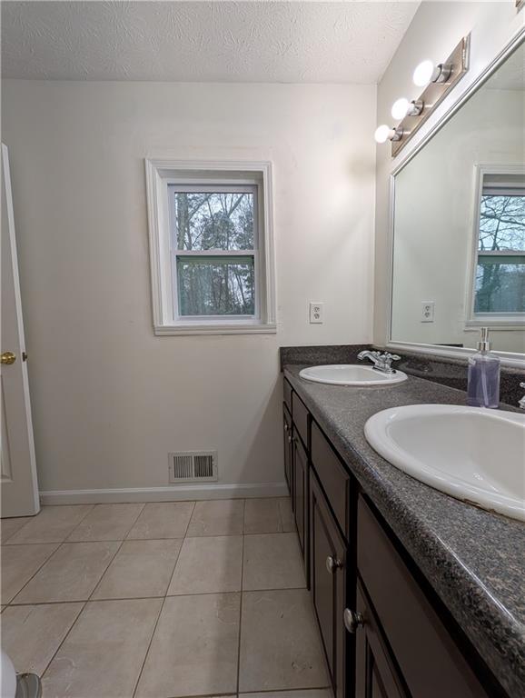 355 Shannon Way Lawrenceville, GA 30044 - Photo 10 of 42 a bathroom with a granite countertop sink a toilet and a mirror
