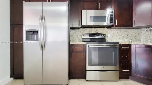 a kitchen with cabinets stainless steel appliances and a counter top space