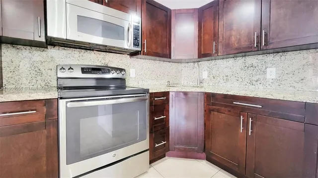 a kitchen with granite countertop cabinets stainless steel appliances and a sink