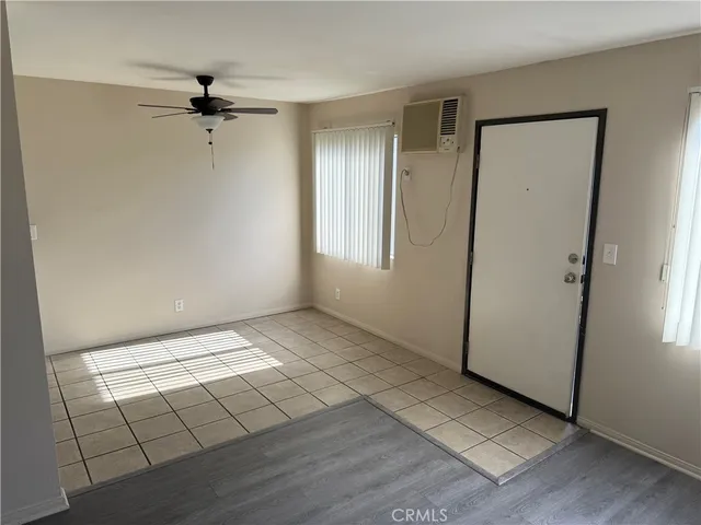 a view of an empty room with wooden floor and closet