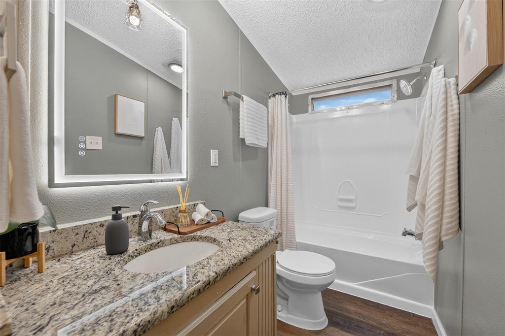 449 Big Salty Lane Springtown, TX 76082 - Photo 14 of 25 Bathroom featuring a vanity with a granite-style countertop, an integrated sink, and an illuminated mirror