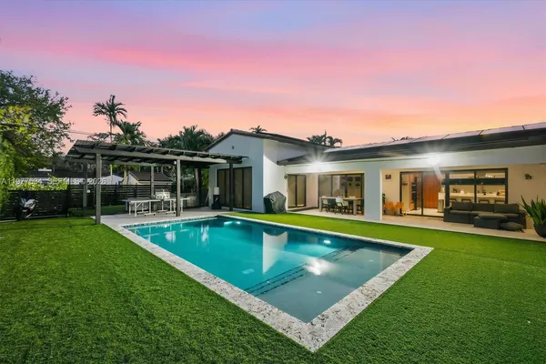 a view of a house with a backyard patio and swimming pool