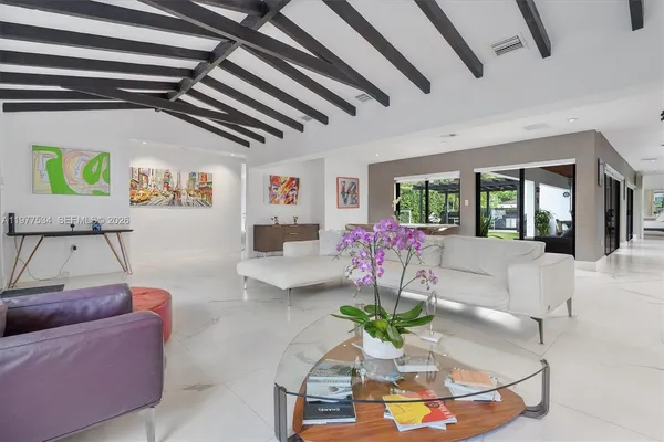 a living room with furniture and a floor to ceiling window