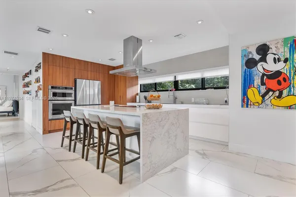 a kitchen with stainless steel appliances kitchen island granite countertop a table and chairs in it