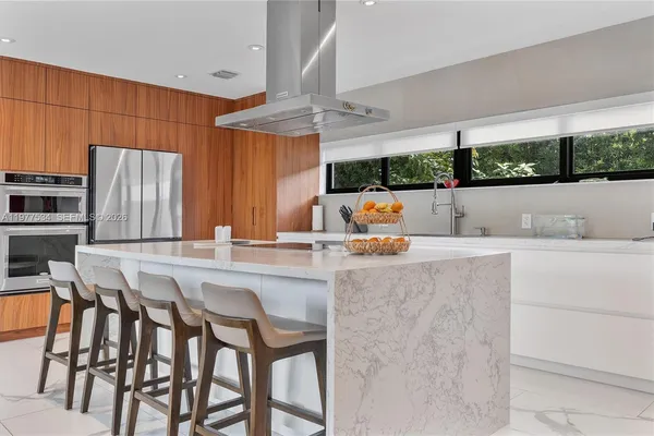 a kitchen with a table chairs sink and cabinets