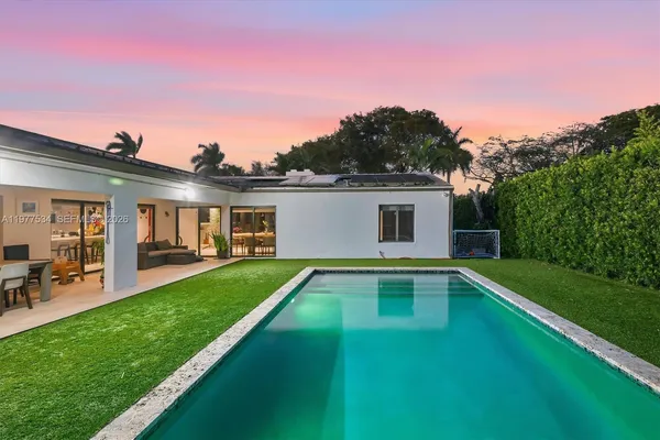 a view of a house with pool porch and a yard