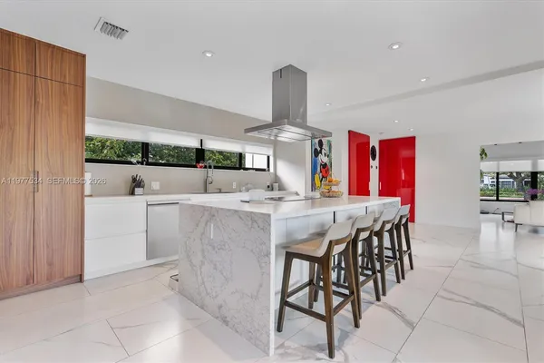 a kitchen with stainless steel appliances kitchen island granite countertop a table and chairs in it