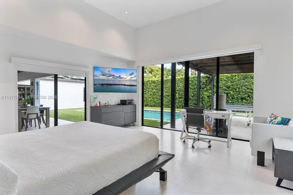a large bedroom with table and large windows