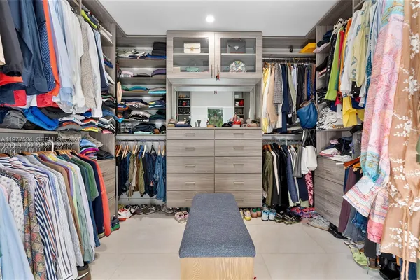 a view of walk in closet with clothes