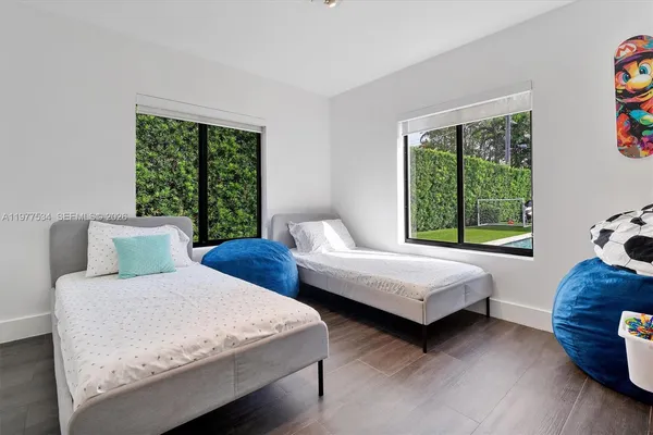 a bedroom with two beds and a large window