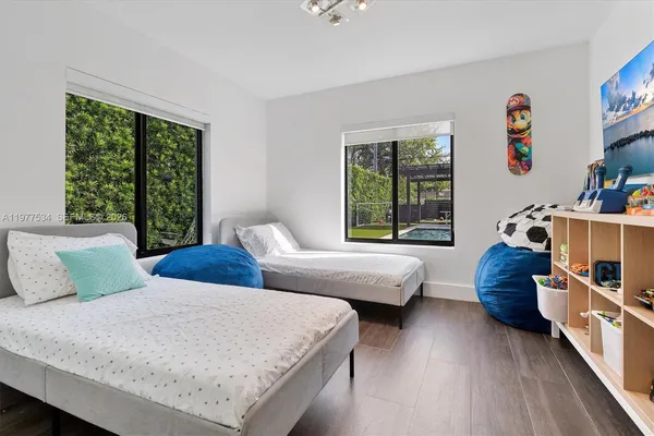 a bedroom with two beds and a large window