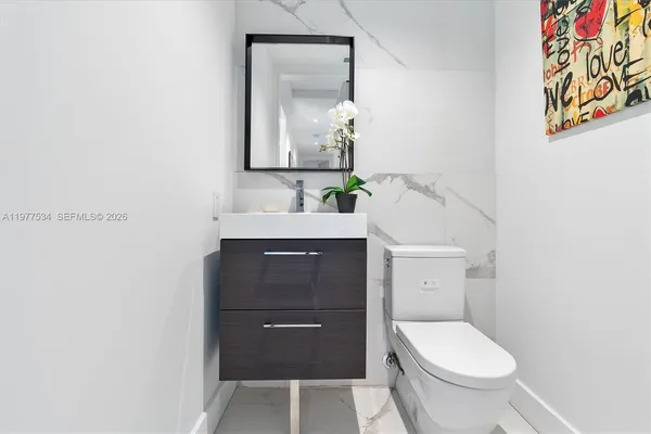 a bathroom with a toilet sink and mirror