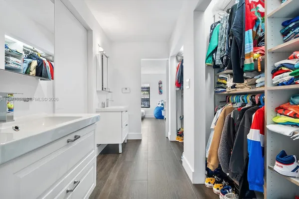 a view of walk in closet with clothes and shoes
