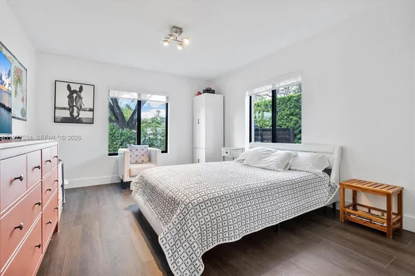 a bedroom with a bed wooden floor and window