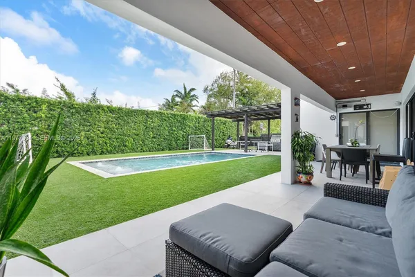 a view of a patio with couches chairs and a big yard