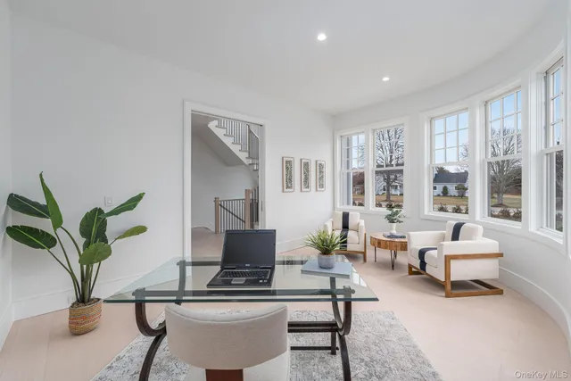a living room with furniture and floor to ceiling windows
