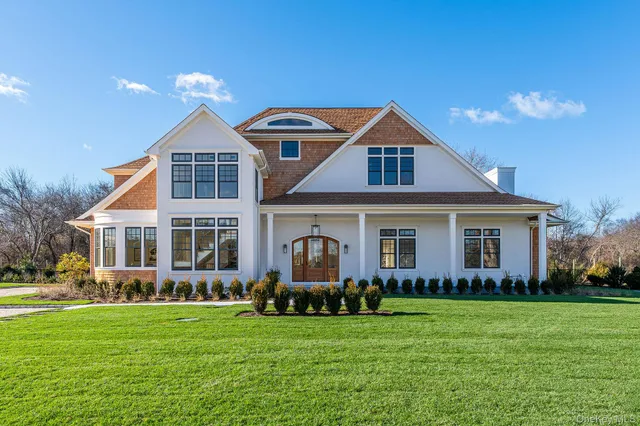 a front view of a house with a garden and yard