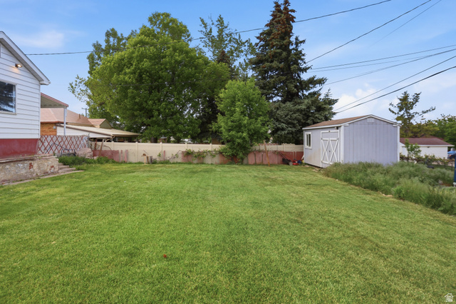 774 37th Street South Ogden, UT 84403 - Photo 29 of 47 Expansive backyard featuring a green lawn, mature trees, and a detached storage shed