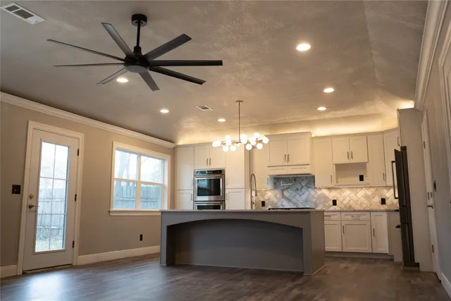 a open kitchen with a sink and dishwasher a stove with wooden floor