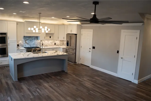 a kitchen with kitchen island a sink stainless steel appliances and cabinets