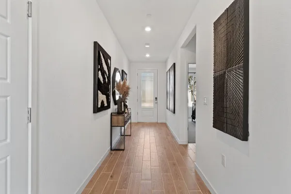a bedroom with a bed a potted plant and a dresser next to a window