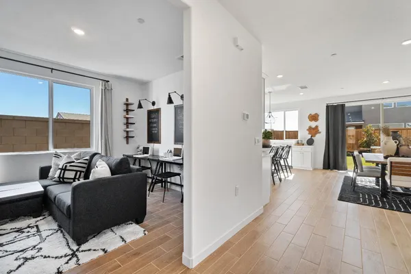 a living room with furniture a flat screen tv and a large window