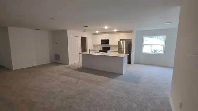 a kitchen with a sink stainless steel appliances and white cabinets