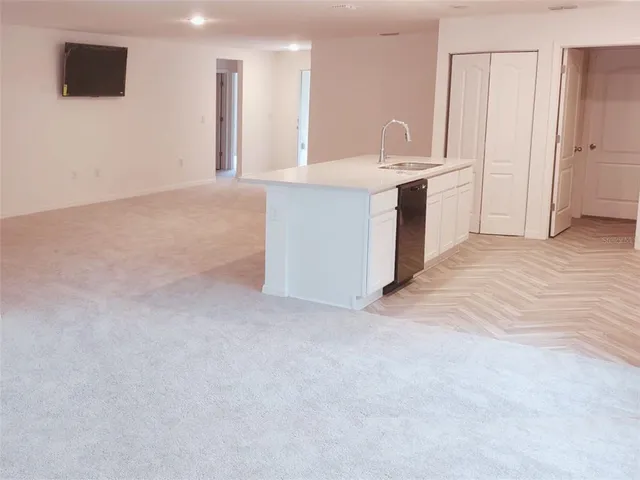 a view of kitchen with kitchen island sink refrigerator and white cabinets