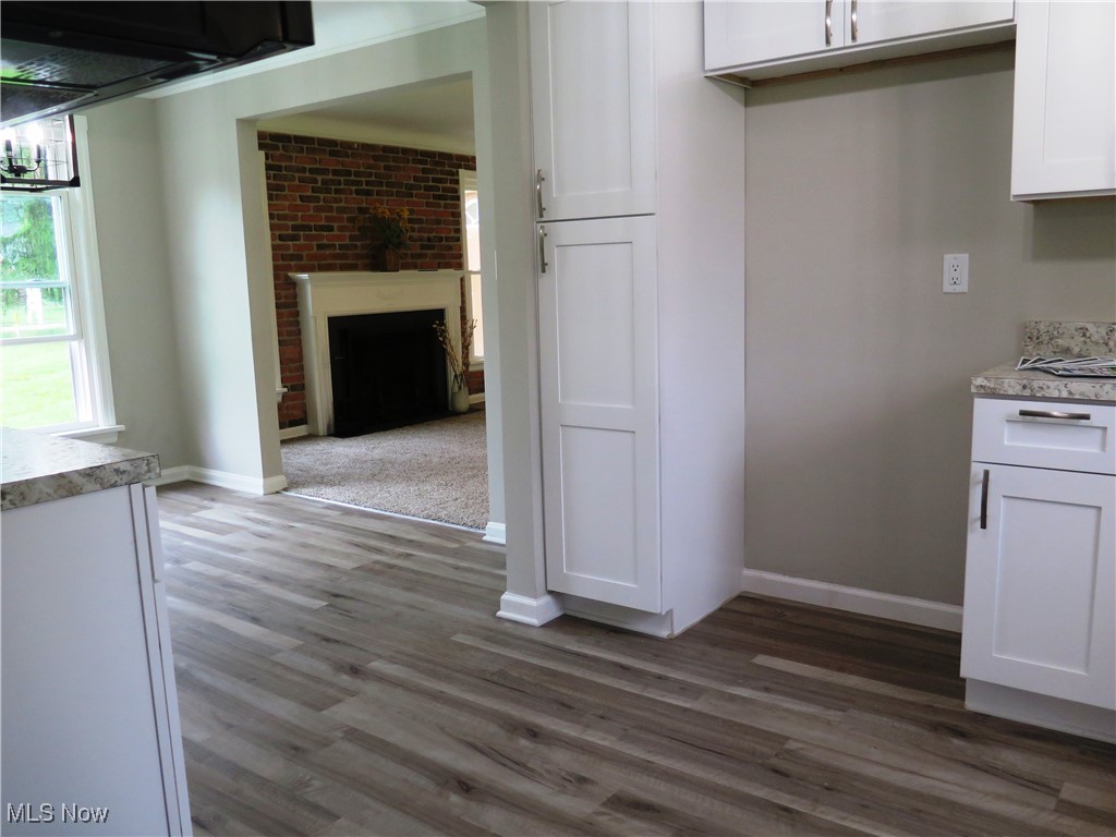 26836 Cook Road Olmsted Falls, OH 44138 - Photo 8 of 23 Kitchen featuring white cabinets, wood finished floors, and a brick fireplace