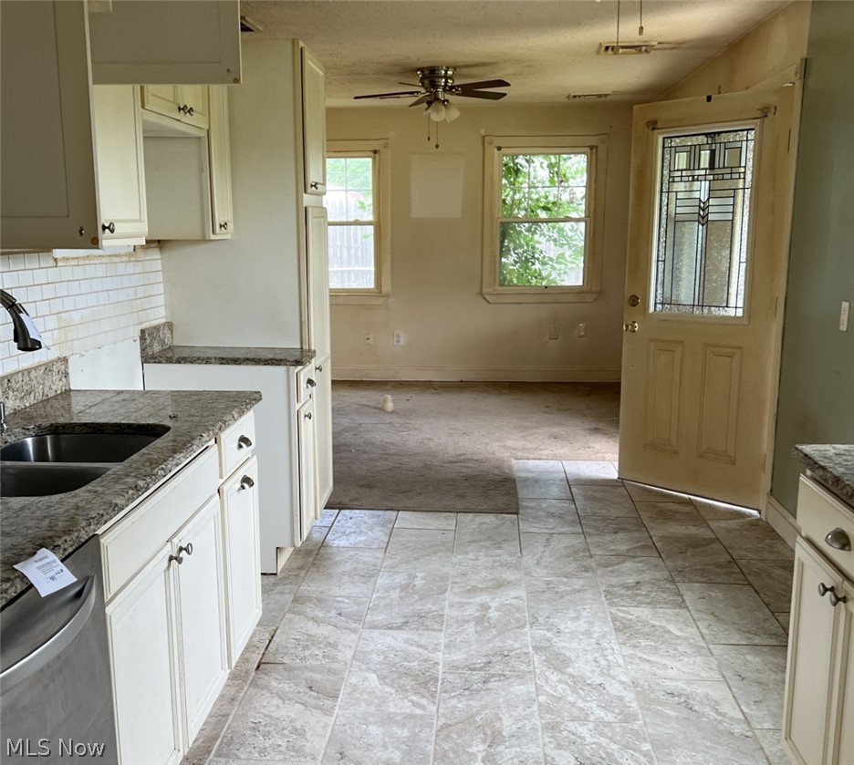 4940 Wake Robin Road Mentor, OH 44060 - Photo 2 of 9 Kitchen with ceiling fan, decorative backsplash, sink, dark stone countertops, and light tile patterned floors