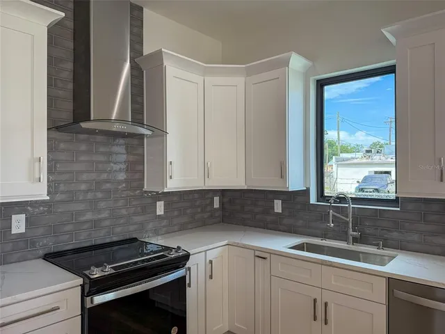 a kitchen with a refrigerator a sink and dishwasher with wooden floor