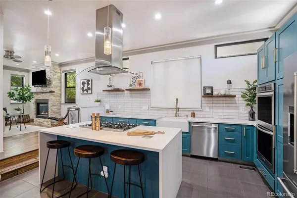 a kitchen with stainless steel appliances granite countertop a sink a stove and a wooden floors
