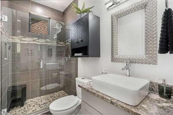 a bathroom with a sink a toilet and shower