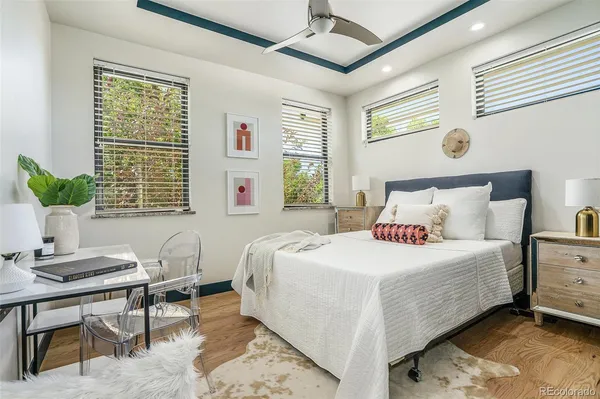 a bedroom with a bed table chair and a window
