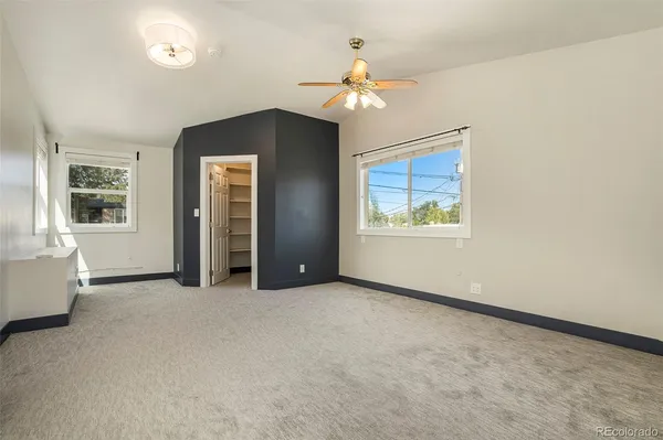 an empty room with windows and chandelier