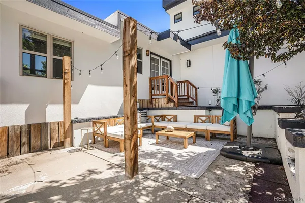 a view of a patio with table and chairs with wooden floor and fence