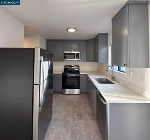 a kitchen with granite countertop a refrigerator and a sink