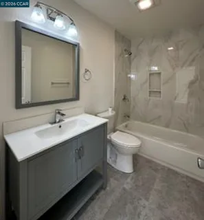 a bathroom with a double vanity sink toilet mirror and bathtub